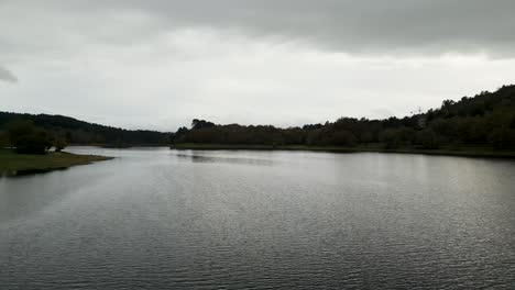 Beautiful-aerial-drone-shot-of-the-landscape-of-the-Cachamuiña-reservoir-on-a-cloudy-day-surrounded-by-trees