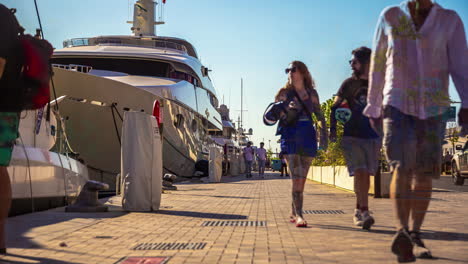 Holiday-makers-strolling-along-a-dock-or-boulevard-with-large-yacht---Spain,-Malaga