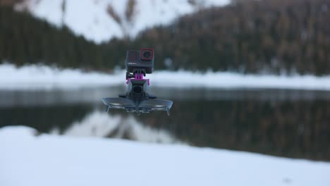 Dron-Con-Cámara-De-Acción-Creativa-Insta360-Ace-Pro-Montada-En-La-Cima-Y-Un-Paisaje-Montañoso-Nevado-Y-Un-Lago-En-El-Fondo