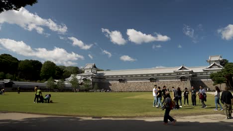 Turistas-En-El-Césped-Del-Parque-Frente-A-Gojukken-Nagaya---Castillo-De-Kanazawa-En-Un-Día-Soleado-Por-La-Tarde