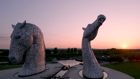 „Drohnenaufnahmen-Mit-Langsamer-Umlaufbahn-Der-Kelpies-Im-Helix-Park,-Die-Die-Details-Der-Skulpturen-Vor-Einem-Atemberaubenden-Violetten-Und-Rosa-Sonnenuntergangshimmel-Einfangen