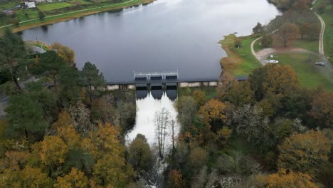 Compuertas-Hidráulicas-Del-Embalse-De-Cachamuiña-Dejando-Pasar-El-Agua-En-Un-Día-Nublado-Rodeado-De-árboles-En-Invierno