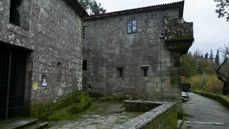 Majestic-old-construction-of-gray-laminated-bricks-with-windows-surrounded-by-trees-and-nature