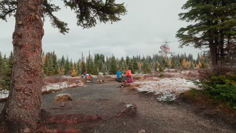 Vibrant-foliage-in-a-lush-wilderness-backcountry-and-landing-helicopter-being-guided-in-by-the-ground-crew-staff