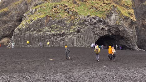 Gente-Caminando-En-La-Playa-De-Arena-Negra-De-Reynisfjara-En-Un-Día-Lluvioso-En-El-Sur-De-Islandia