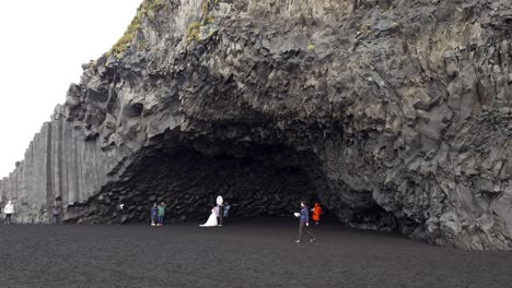 Fotoshooting-Eines-Ehepaares-Am-Schwarzen-Sandstrand-Von-Reynisfjara-An-Einem-Regnerischen-Tag-In-Island-–-Weitwinkel