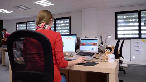 Orbiting-shot-of-a-worker-working-at-a-computer-in-an-office-setting