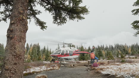 Helicopter-taking-off-from-a-vibrant-autumn-foliage-field-in-a-lush-wilderness-backcountry,-a-very-noticeable-prop-wash