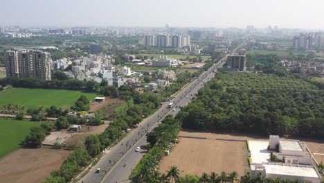 aerial-drone-shot-The-drone-camera-is-moving-forward-where-high-rise-buildings-and-low-rise-buildings-are-visible-and-there-are-many-trees-around-and-many-vehicles-on-the-road