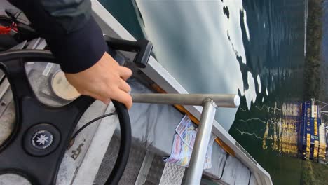 Man-driving-motorboat-at-stunning-Milford-Sound-fjord-New-Zealand,-vertical-shot