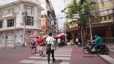 People-Crossing-the-Street-in-Chinatown-in-Bangkok,-Thailand