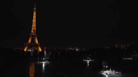 Tourist-Takes-Photos-of-Himself-While-Holding-Red-Balloons-in-Front-of-Eiffel-Tower-at-Night-in-Place-du-Trocadero