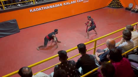 pov-shot-Foreno-is-clapping-while-watching-the-bets-and-two-people-are-making-bets-in-the-arena