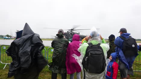 La-Gente-En-El-Salón-Aeronáutico-Se-Encuentra-Cerca-De-Un-Helicóptero-De-Ataque-Militar-Que-Gira-Las-Palas-Del-Rotor.