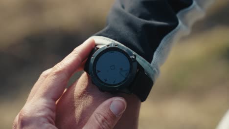 Mann-überprüft-Seine-Garmin-Uhr-Während-Einer-Wanderung-In-Den-Bergen