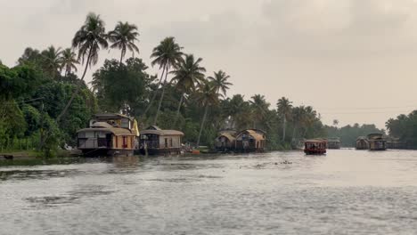 In-Der-POV-Aufnahme-Sind-Viele-Boote-Mitten-Im-Wasser-Unterwegs,-Um-Touristen-Abzuholen,-Und-Rund-Um-Das-Wasser-Stehen-Viele-Große-Bäume