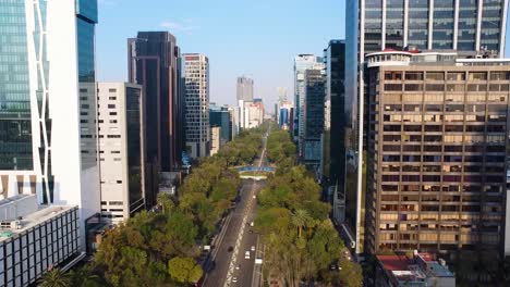 Vuelo-Aéreo-Sobre-La-Carretera-Principal-De-La-Ciudad-De-México-Entre-El-Horizonte-Y-La-Rotonda-Del-Monumento-Al-Ángel-De-La-Independencia-Al-Amanecer.