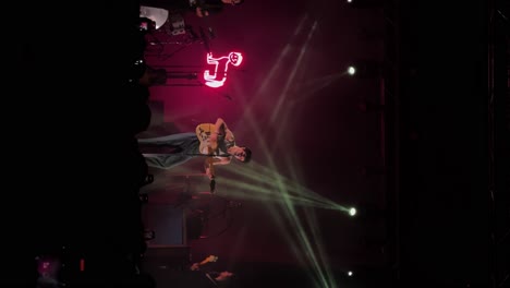 Vertical-handheld-medium-shot-of-Samuel-Holden-Jaffe-playing-guitar,-singing-and-performing-live-in-concert-as-the-Del-Water-Gap-band-with-colorful-stage-lighting-at-the-Complex-in-Salt-Lake-City-Utah