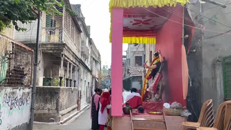 Side-view-of-a-pandal-with-devotees-worshipping-the-god-in-Kolkata,-India