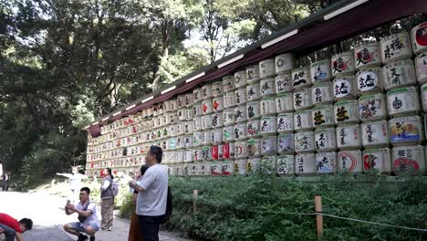 Touristen-Fotografieren-Neben-Der-Dekorativen-Wand-Aus-Sake-Fässern-Am-Meji-Schrein