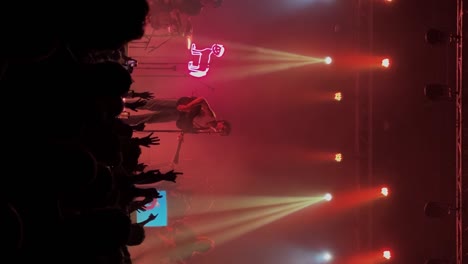 Vertical-handheld-medium-shot-of-Samuel-Holden-Jaffe-playing-guitar-and-singing-performing-live-in-concert-as-the-Del-Water-Gap-band-with-orange-stage-lighting-at-the-Complex-in-Salt-Lake-City-Utah