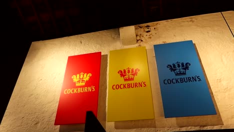 Buntes-Logo-Von-Cockburns-Weinkeller,-Beleuchtet-Durch-Licht-Im-Keller,-Bewegungsansicht