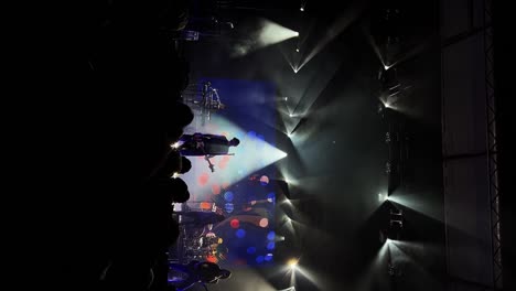 Vertical-medium-handheld-shot-of-Tyson-Ritter-and-the-All-American-Rejects-band-playing,-singing,-and-performing-live-in-concert-at-the-The-Great-Saltair-Amphitheater-in-Utah-with-flashing-lights