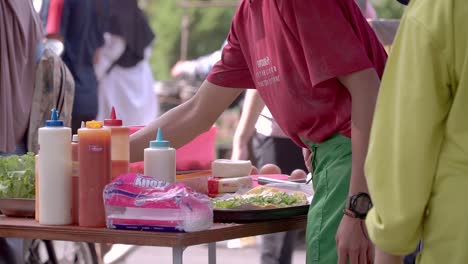 El-Vendedor-Ambulante-De-Comida-Está-Preparando-Sándwiches-En-La-Mesa-Para-Los-Clientes.