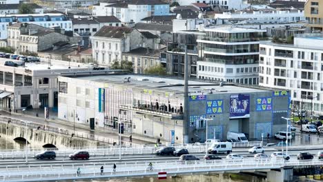 The-CAP-Sciences-children-education-museum-at-the-Garonne-River-shore-and-Delmas-traffic-bridge,-Aerial-zoom-in-shot