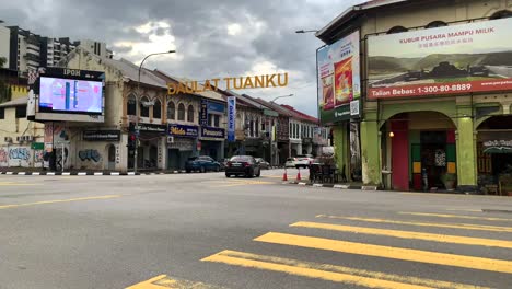 Una-Vista-De-La-Calle-En-El-Centro-De-La-Ciudad-De-Ipoh-Malasia-Con-Automóviles,-Carriles-Peatonales-Y-Edificios-Comerciales.