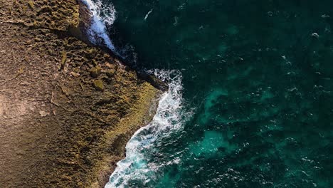 Vista-Aérea-Estática-De-Pájaro-Del-Punto-De-Roca-Volcánica-Con-Olas-Rompientes