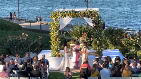 Pareja-De-Lesbianas-Durante-La-Ceremonia-De-Boda-India-Y-Caucásica-En-San-Diego,-Bahía-De-Coronado