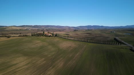 Hileras-De-Césped-Cortado-Se-Sientan-Debajo-De-La-Mansión-En-Val-D&#39;orcia-Toscana-Con-Una-Carretera-épica-Que-Conduce-A-La-Villa