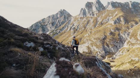 Man-walking-in-the-mountains-with-a-backpack