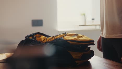 Man-zipping-his-The-North-Face-backpack-for-a-hike-in-the-living-room