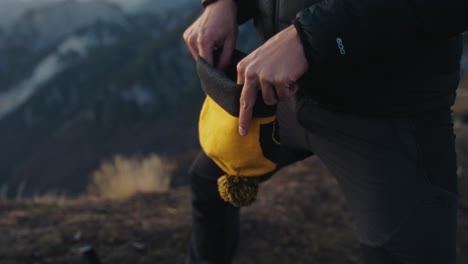 Hombre-Poniéndose-Su-Gorro-Durante-Una-Caminata-Por-Las-Montañas