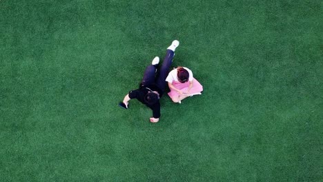 Young-chinese-asian-couple-date-taking-pictures-on-university-football-field