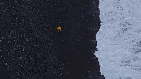 Hombre-Adulto-Caminando-Por-La-Playa-De-Arena-Negra-En-Azores-Portugal---Disparo-De-Drone