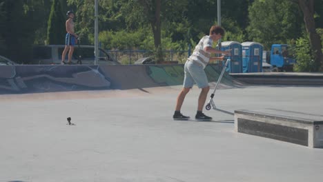 Mann-Mit-Stunt-Scooter-Führt-Rutsche-Und-180-Grad-Drehtrick-Im-Skatepark-Durch