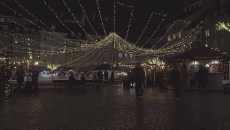 People-Walk-at-Old-Town-Market-Square-with-Lighting-Decoration-in-Warsaw-Poland-during-Foggy-Night