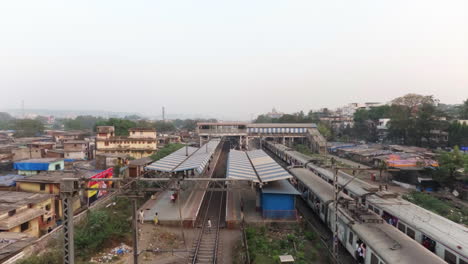 Züge,-Die-An-Einem-Von-Slums-Umgebenen-S-Bahnhof-Vorbeifahren