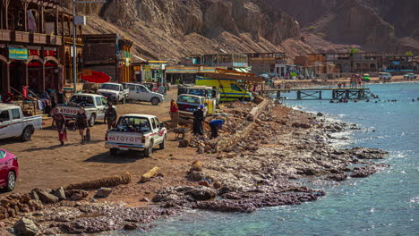 Shot-of-tourist-vehicles-along-the-shore-with-waves-crashing-in-timelapse-in-Xlendi-Beach-in-Malta