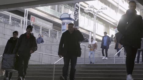 City-dwellers-ascend-and-descend-stairs-from-a-subway-station-in-golden-sunlight