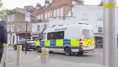 Furgoneta-De-Policía,-En-El-Centro-De-Londres,-Espera-Detrás-Del-Vehículo-Mientras-La-Gente-Cruza-La-Calle