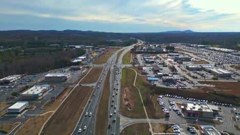 Langsamer-Verkehr-Auf-Der-Amerikanischen-Autobahn-In-Der-Nähe-Von-Atlanta-City-Mit-Hügeln-Im-Hintergrund-An-Sonnigen-Tagen---Weitwinkelaufnahme-Aus-Der-Luft