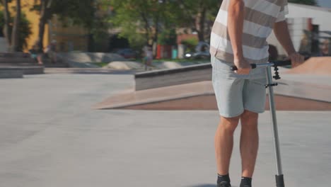 El-Hombre-En-Scooter-Acrobático-En-El-Skatepark-Realiza-Deslizamiento-Y-Giro-De-Barra-Durante-La-Práctica