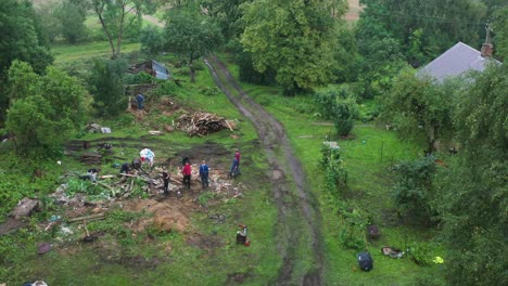 Familiares-Y-Parientes-Ayudan-A-Limpiar-El-Patio-Rural-De-Basura-Vieja