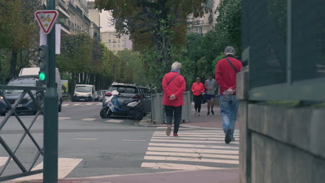 Pareja-De-Ancianos-Cruzando-Una-Calle-En-Un-Barrio-Suburbano