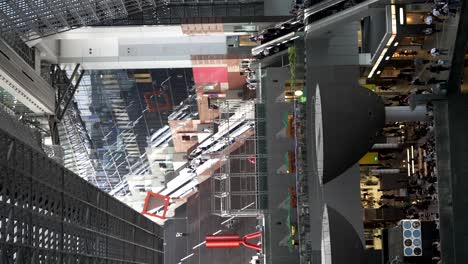 Vertical-video-of-Kyoto-public-transport-station,-giant-staircase-inside,-crowded,-Japan