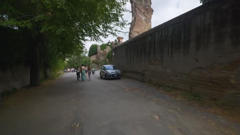 Punto-De-Vista-Inmersivo-En-Roma:-Moverse-Por-Calles-Concurridas-Hasta-Chiesa-Santi-Luca-E-Martina,-Italia,-Europa,-Caminar,-Tembloroso,-4k-|-Familia-Caminando-Cerca-Del-Auto